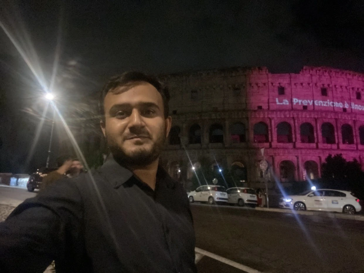 Nighttime selfie near the illuminated Colosseum in Rome